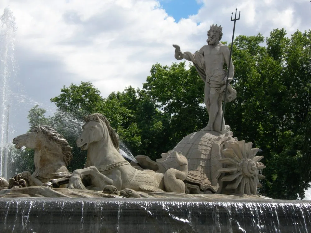 Estatua de Neptuno con el tridente sobre un carro tirado por caballos marinos, en su fuente del paseo del Prado