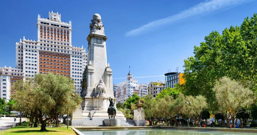 Monumento a Cervantes con las figuras de Don Quijote y Sancho Panza a caballo y el Edificio España al fondo
