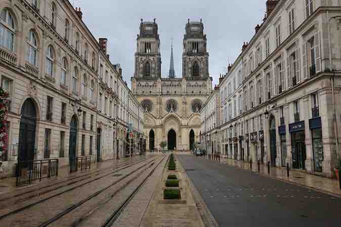 Calle de Orleans con raíles de tranvía y las dos torres de la catedral de Sainte-Croix al fondo