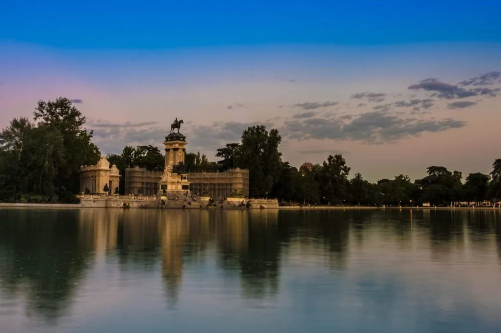 El estanque del Retiro al atardecer con el Monumento a Alfonso XII reflejado en el agua