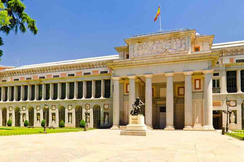 Fachada y columnata del Museo del Prado con la estatua de Velázquez ante la entrada