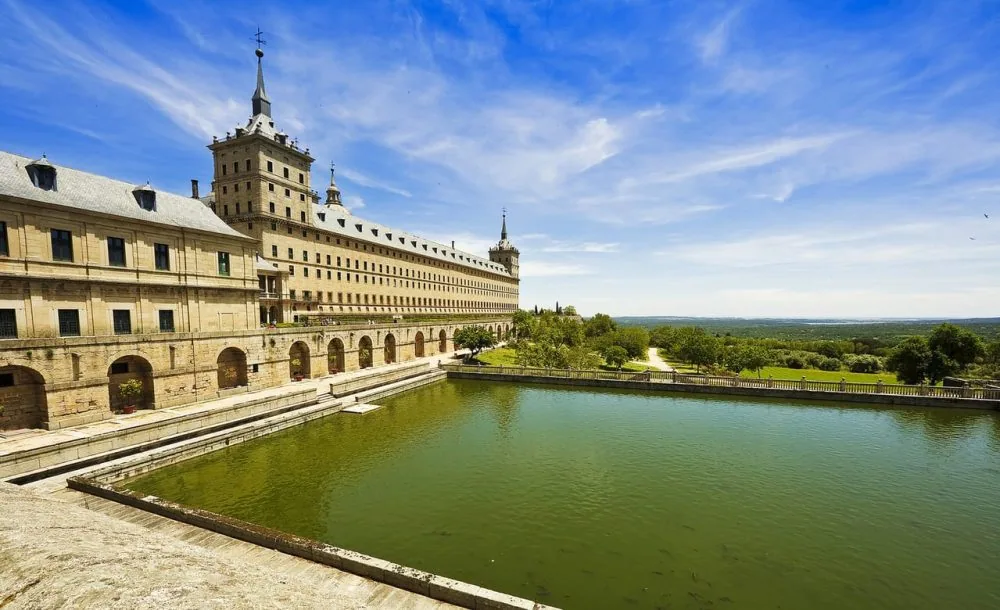 El Monasterio de El Escorial visto desde uno de sus estanques, con la torre y la fachada de granito