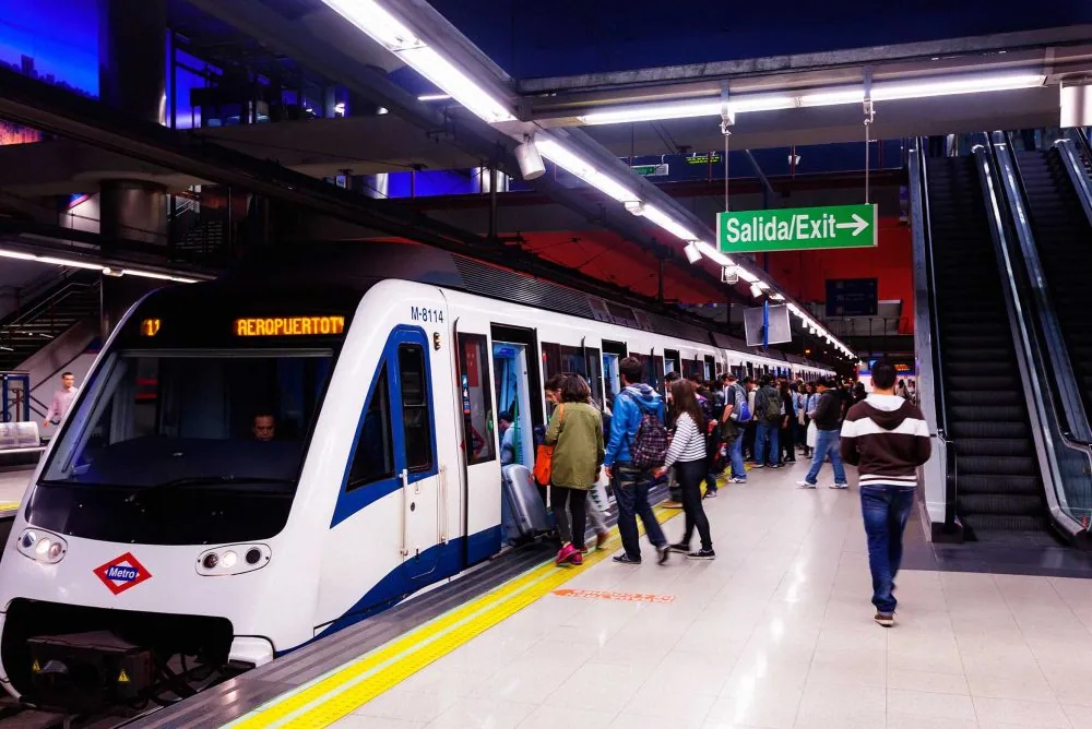 Tren de metro con destino Aeropuerto T4 detenido en el andén mientras los viajeros suben