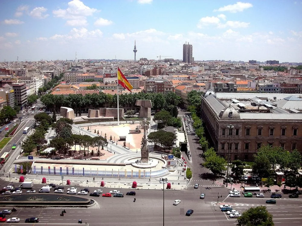 Vista aérea de la Plaza de Colón con la gran bandera de España y la Biblioteca Nacional a la derecha