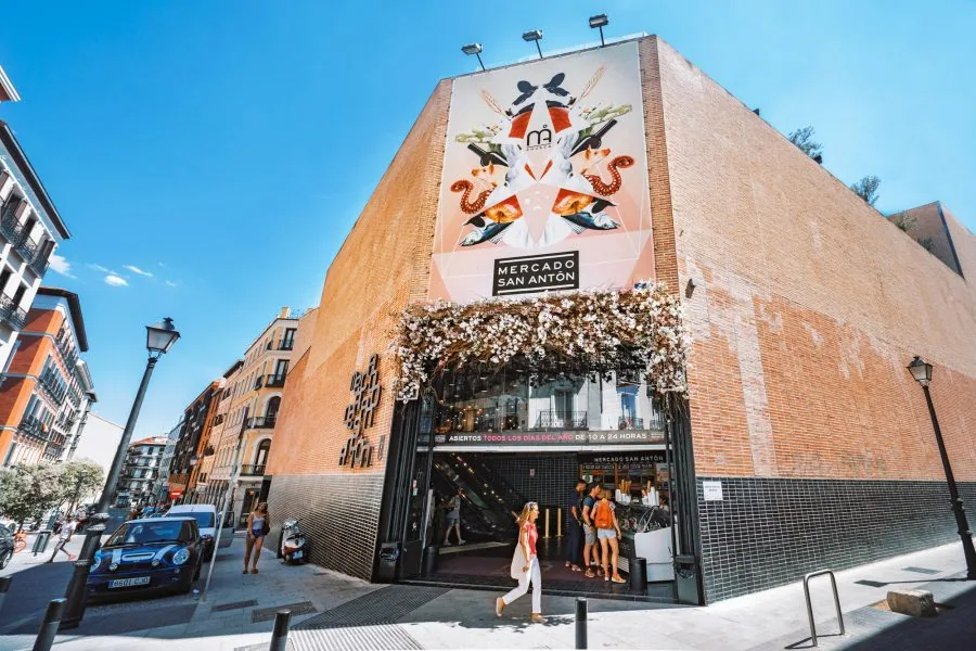 Esquina del Mercado de San Antón con el mural de su fachada y la entrada cubierta de flores