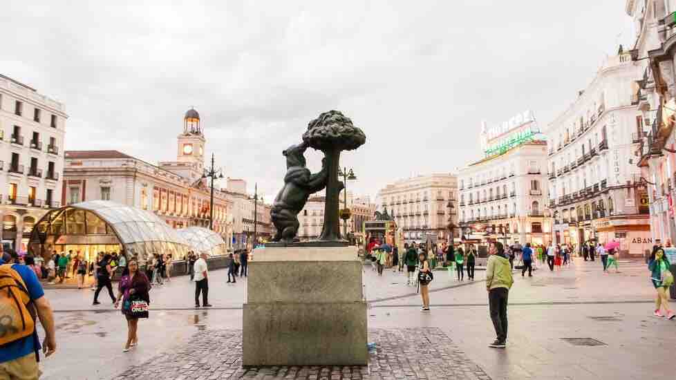 La estatua del Oso y el Madroño en la Puerta del Sol, con el reloj de la Casa de Correos al fondo