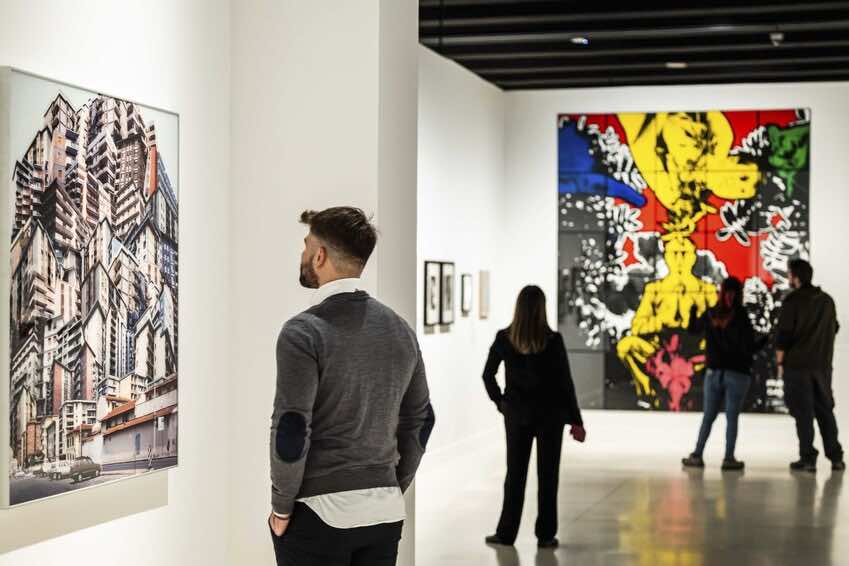 Visitantes contemplando cuadros de gran formato en una sala de museo de arte contemporáneo