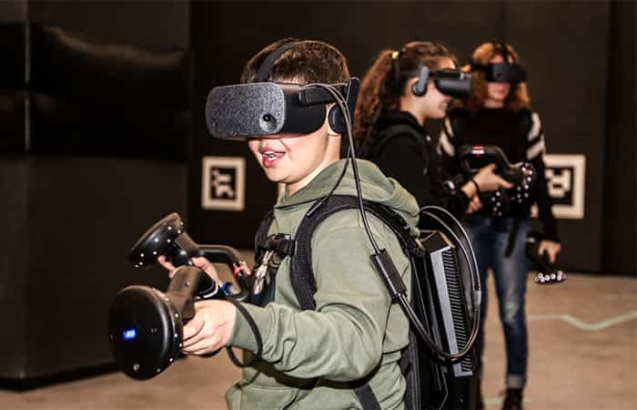 Niño con gafas de realidad virtual y mandos en las manos durante una partida