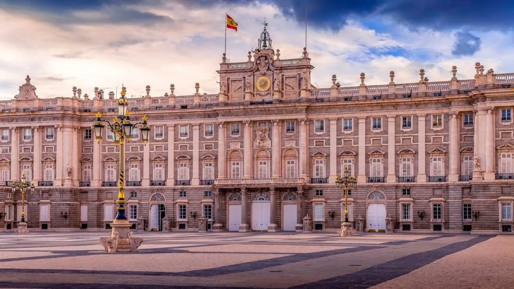 Fachada del Palacio Real desde la Plaza de la Armería, con una farola ornamentada en primer plano